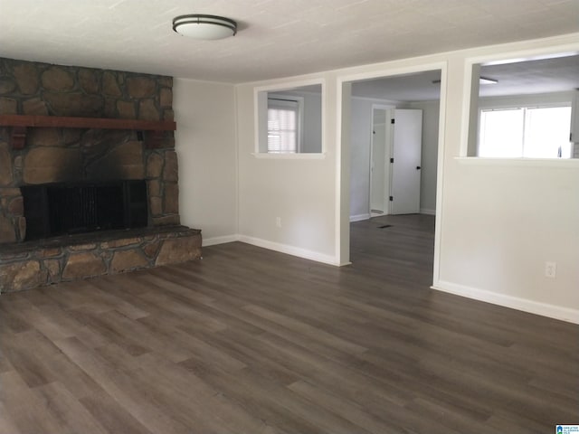 unfurnished living room with dark hardwood / wood-style flooring and a fireplace