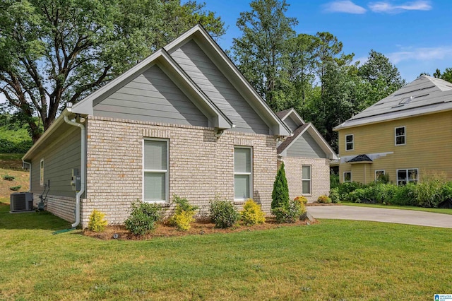 view of front of house featuring central air condition unit and a front lawn