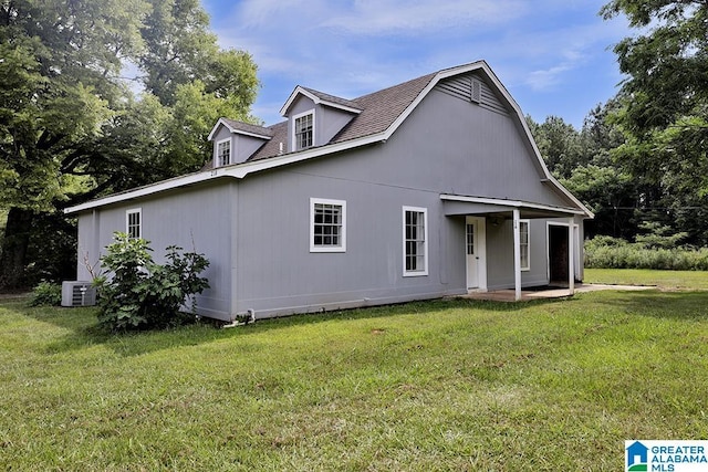 back of house with a lawn and cooling unit