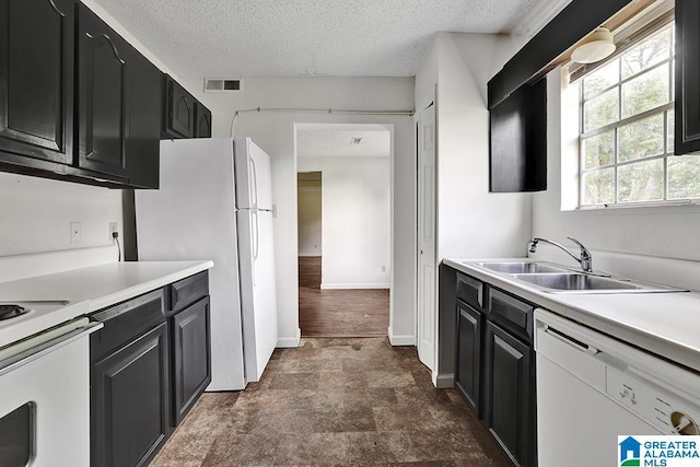 kitchen featuring a textured ceiling, sink, and white appliances