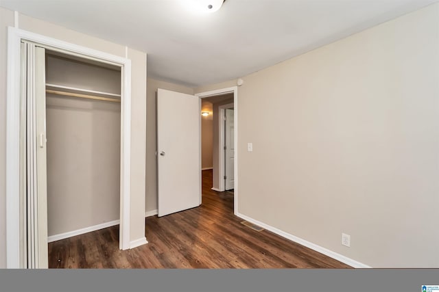 unfurnished bedroom featuring dark hardwood / wood-style flooring and a closet