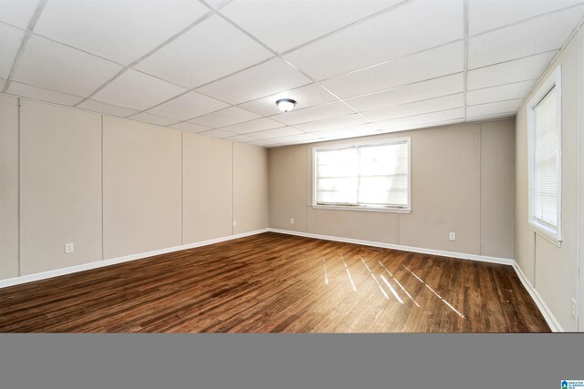 empty room featuring a drop ceiling and dark wood-type flooring