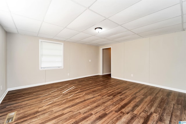 unfurnished room featuring a paneled ceiling and dark hardwood / wood-style floors