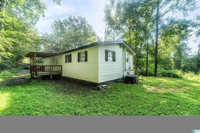 view of property exterior with a yard, central AC unit, and a wooden deck