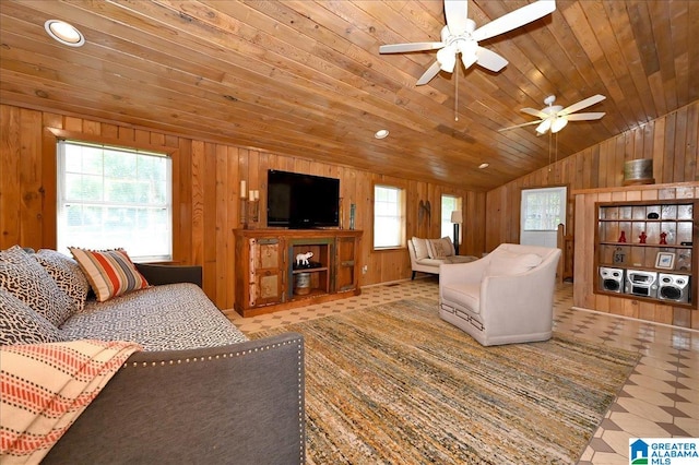 tiled living room featuring a healthy amount of sunlight, wooden walls, ceiling fan, and wood ceiling