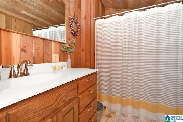 bathroom featuring vaulted ceiling, wood walls, vanity, and wooden ceiling