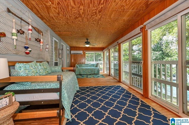 unfurnished sunroom featuring a wall mounted AC, wood ceiling, and ceiling fan