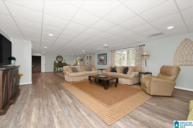 living room featuring hardwood / wood-style floors and a drop ceiling