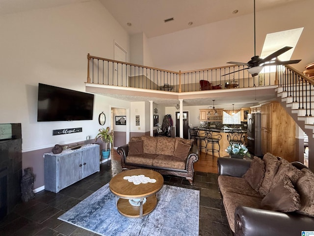 living room with ceiling fan and a towering ceiling