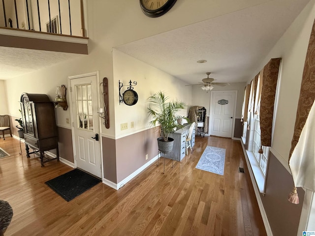 foyer featuring a textured ceiling, hardwood / wood-style flooring, and ceiling fan