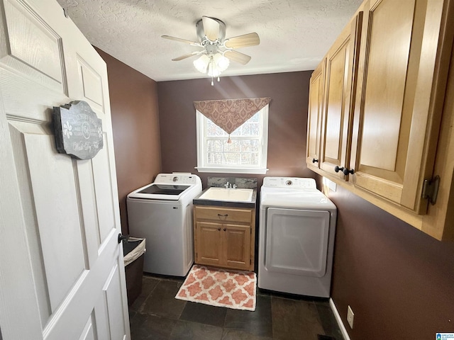 clothes washing area featuring washing machine and clothes dryer, a textured ceiling, ceiling fan, sink, and cabinets