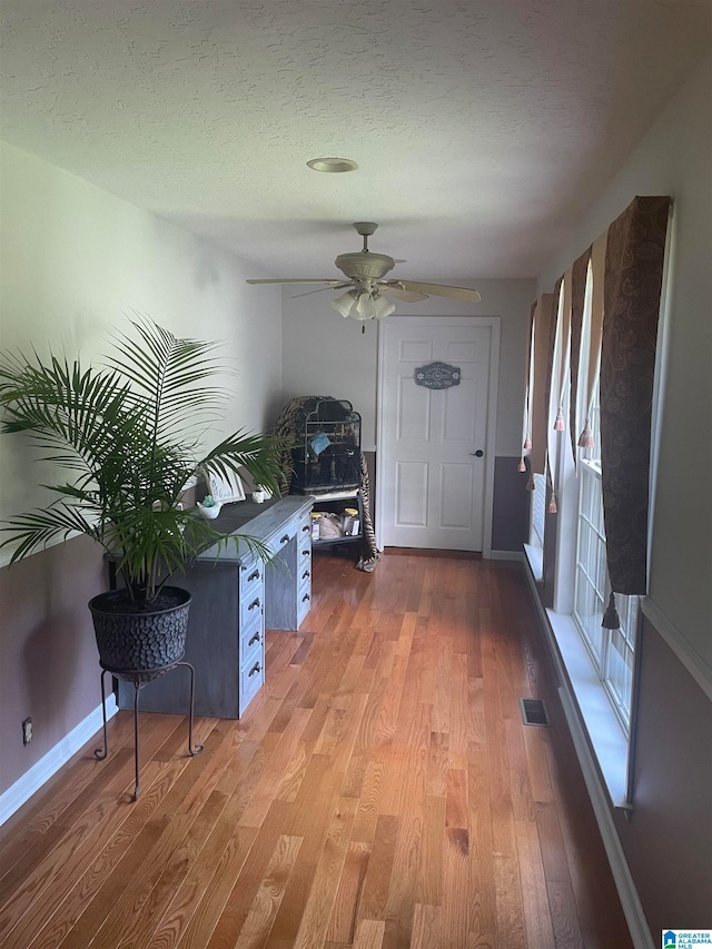 foyer with ceiling fan, a textured ceiling, and hardwood / wood-style flooring