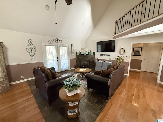 living room with ceiling fan, high vaulted ceiling, wood-type flooring, and french doors