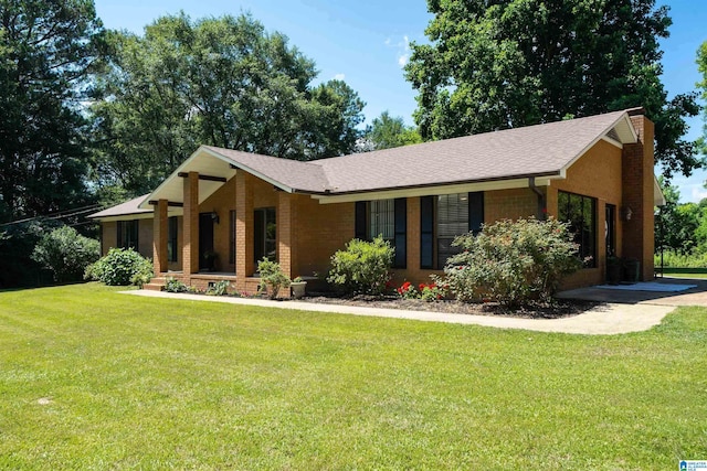 single story home featuring covered porch and a front yard