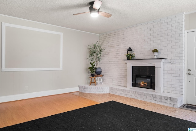 unfurnished living room with wood-type flooring, a textured ceiling, a fireplace, and ornamental molding