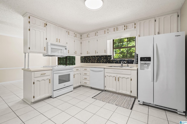 kitchen with sink, white appliances, white cabinetry, and light tile patterned floors