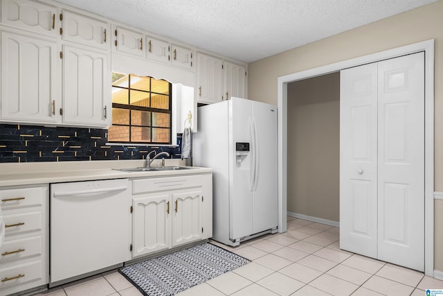 kitchen featuring sink, white appliances, a textured ceiling, and white cabinets