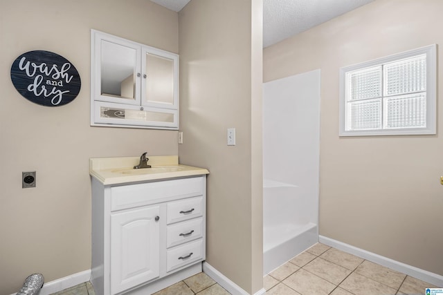 bathroom with vanity, a shower, a textured ceiling, and tile patterned flooring