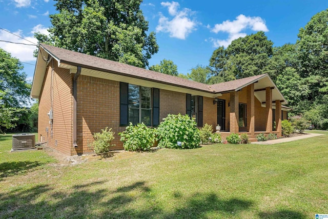 single story home with central air condition unit and a front yard