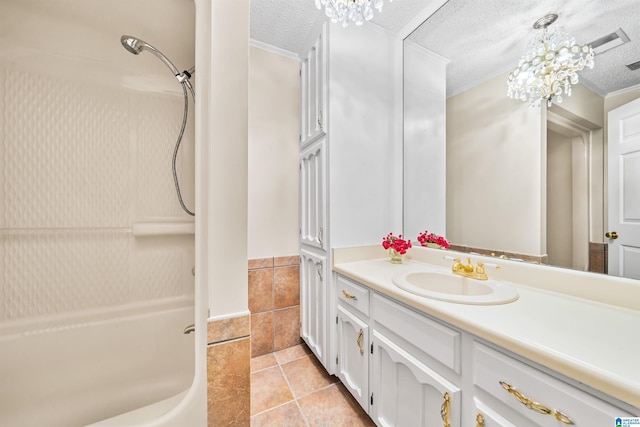 bathroom featuring a textured ceiling, tile patterned flooring, a notable chandelier, and vanity