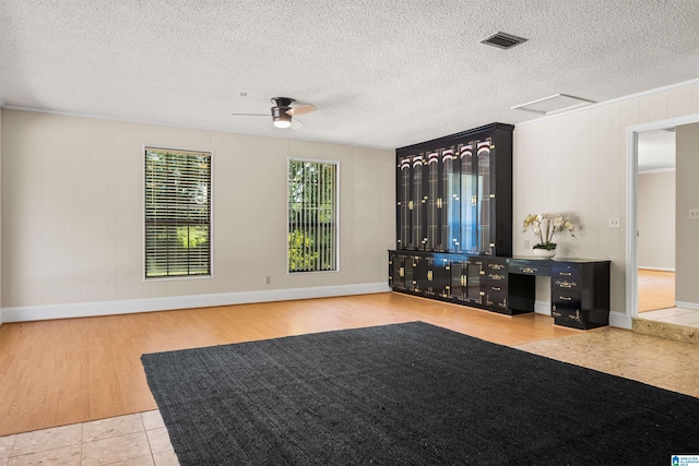 unfurnished living room with ceiling fan, a textured ceiling, and light tile patterned floors