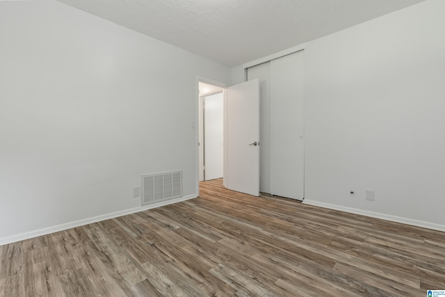 spare room with wood-type flooring and a textured ceiling