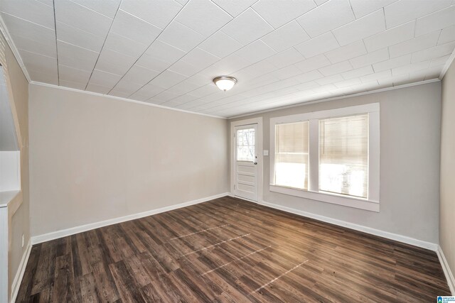 unfurnished room with crown molding and dark wood-type flooring