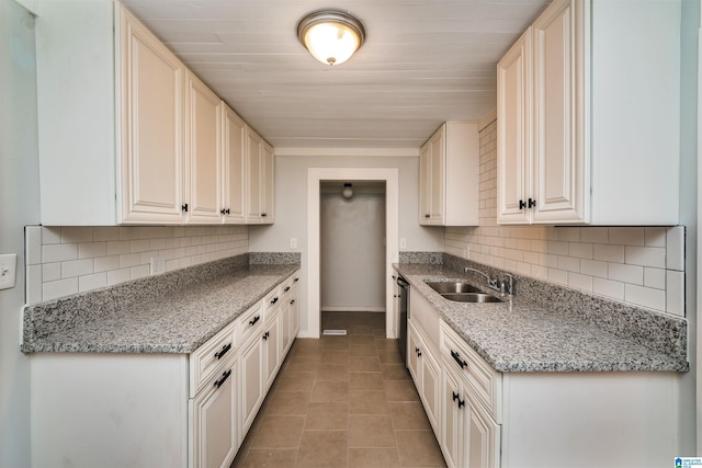 kitchen featuring white cabinets, light stone countertops, sink, and light tile patterned floors