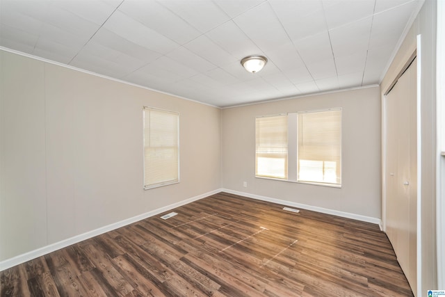 spare room featuring dark hardwood / wood-style floors and ornamental molding