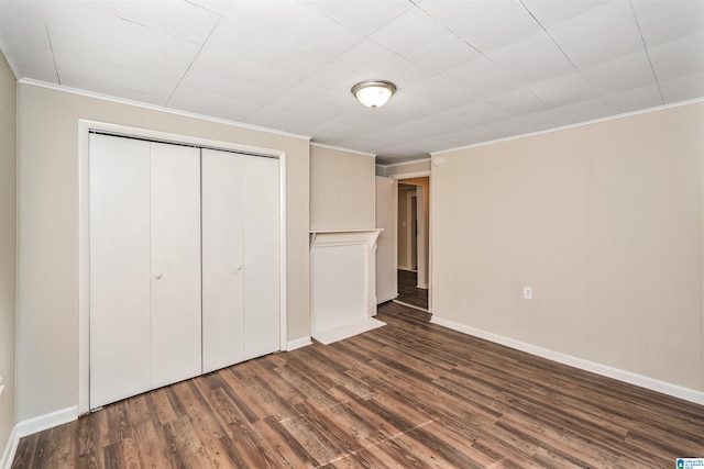 unfurnished bedroom featuring crown molding, a closet, and dark wood-type flooring