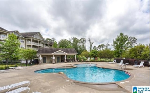 community pool with fence and a patio