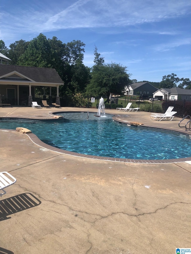 pool with fence and a patio