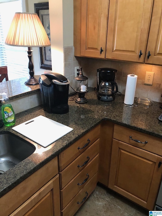 kitchen featuring dark stone countertops and backsplash