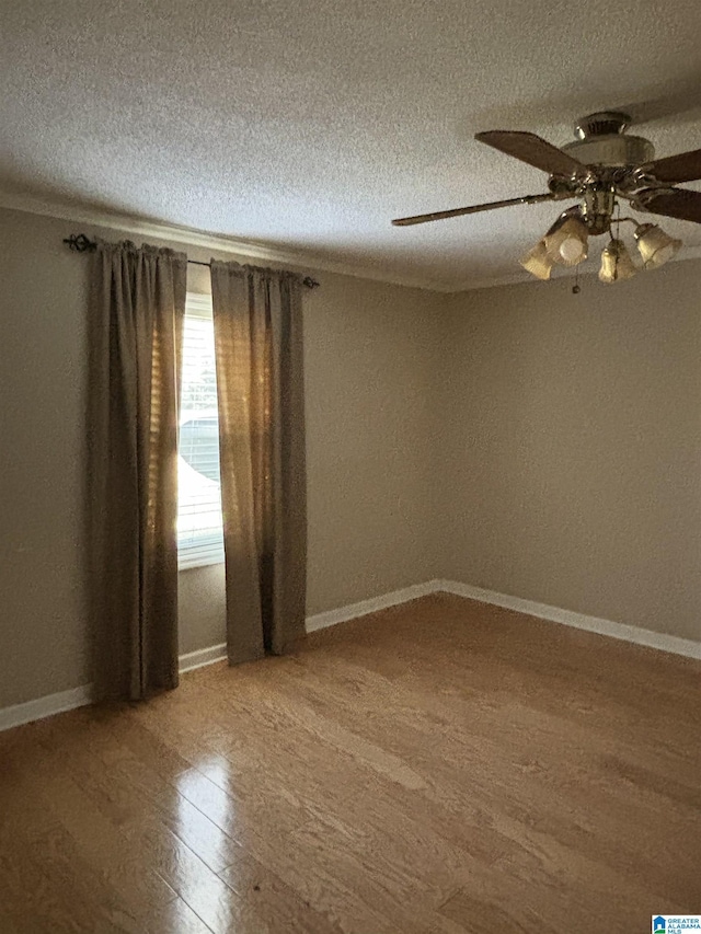 empty room featuring ceiling fan, a textured ceiling, and hardwood / wood-style flooring