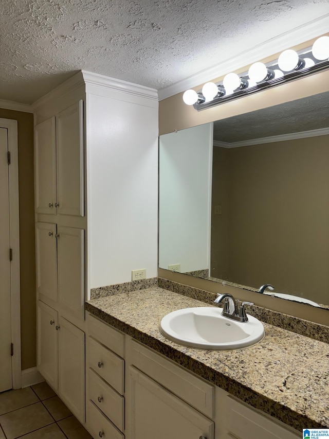 bathroom with tile patterned flooring, vanity, a textured ceiling, and crown molding