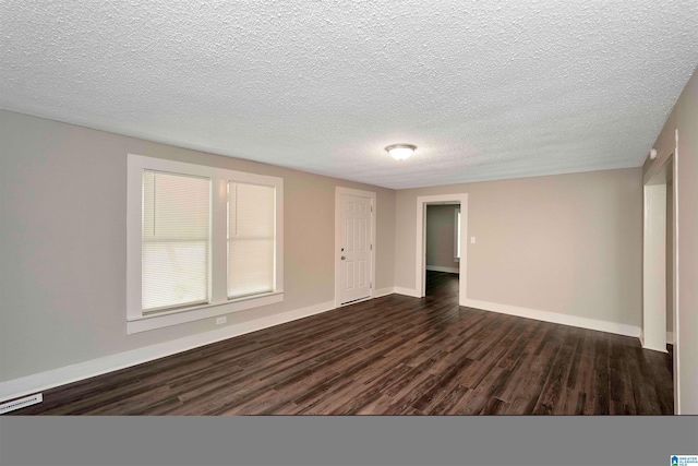 spare room featuring a textured ceiling and dark hardwood / wood-style floors