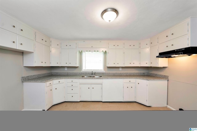 kitchen featuring white cabinets, light tile patterned floors, and sink