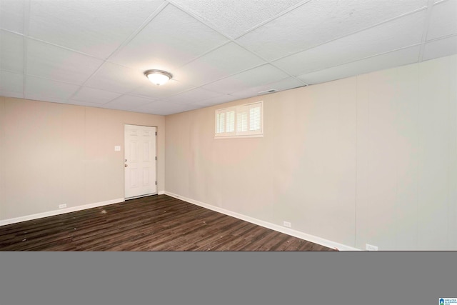 basement featuring a drop ceiling and dark hardwood / wood-style floors