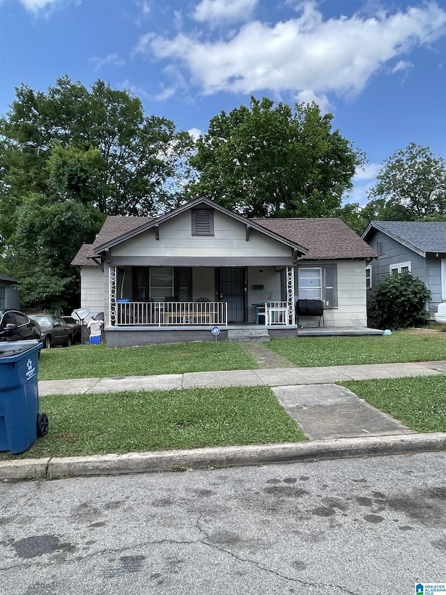 bungalow-style home with covered porch and a front lawn