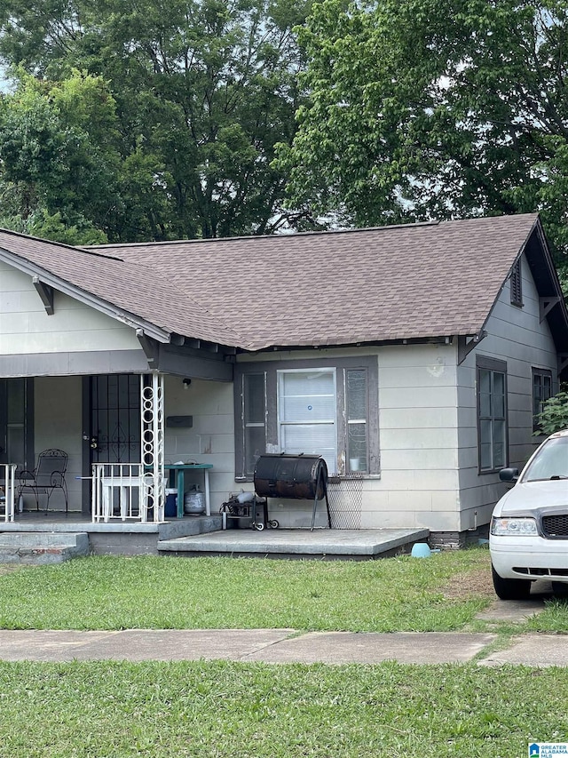 ranch-style house with covered porch and a front lawn