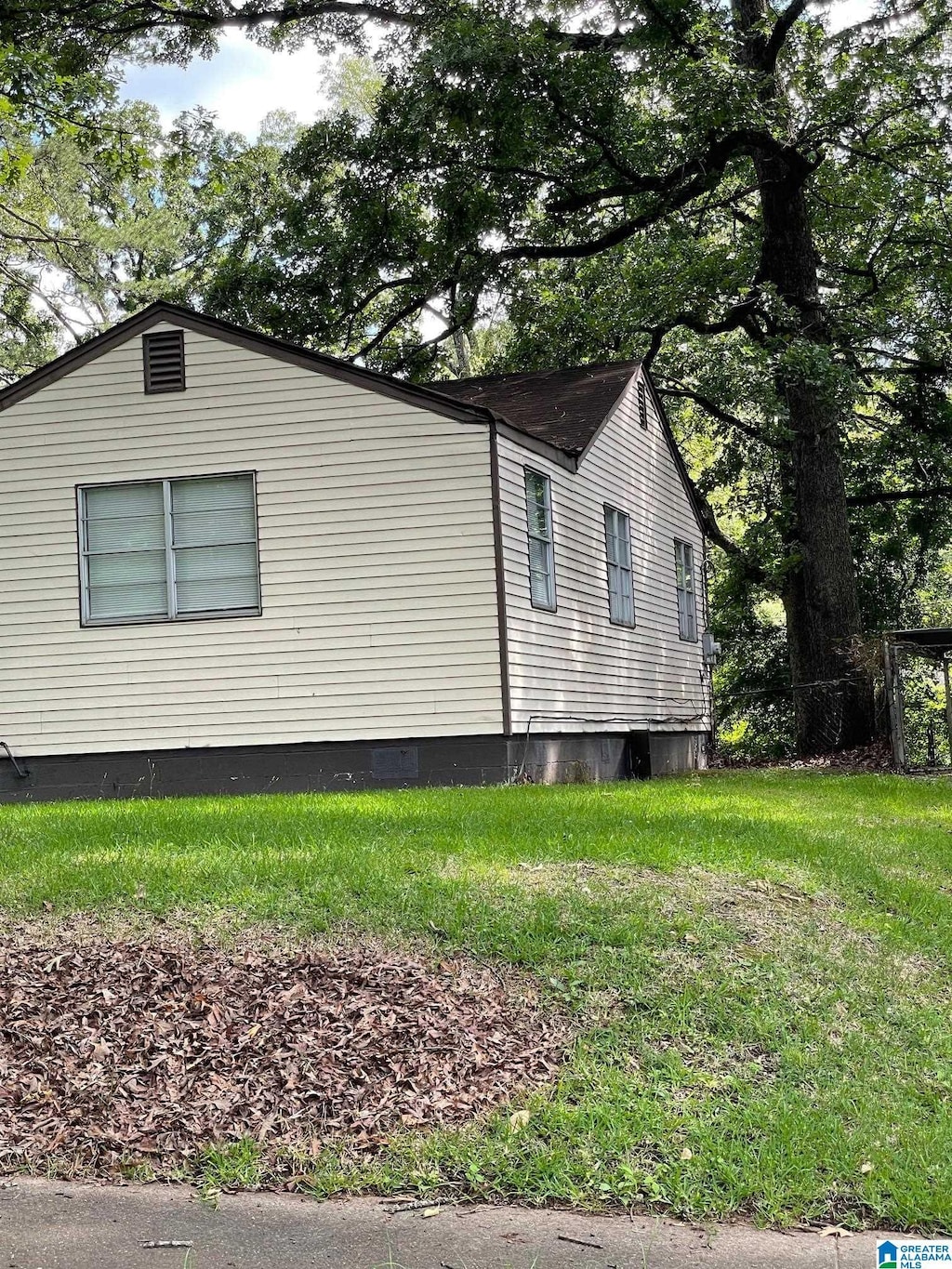 view of side of home with a yard