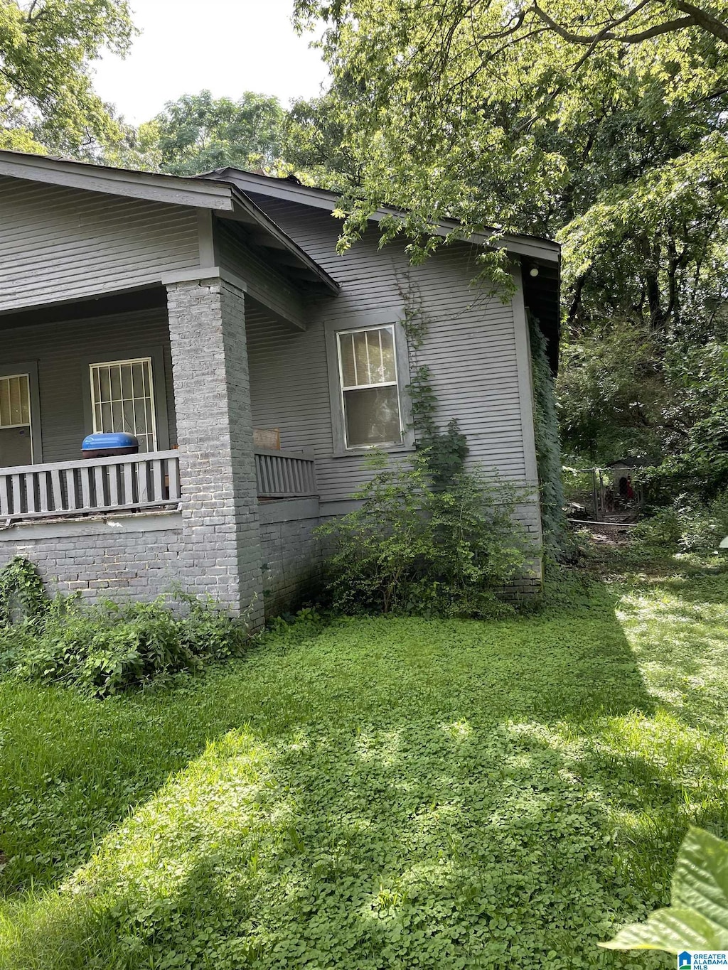 view of home's exterior with covered porch and a yard