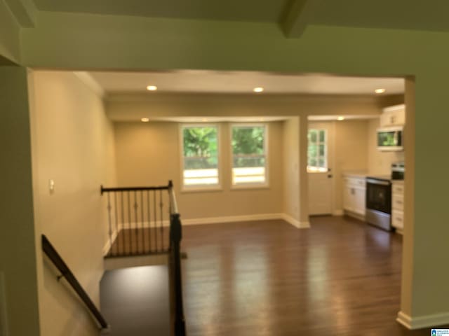 unfurnished room featuring beamed ceiling and dark hardwood / wood-style flooring