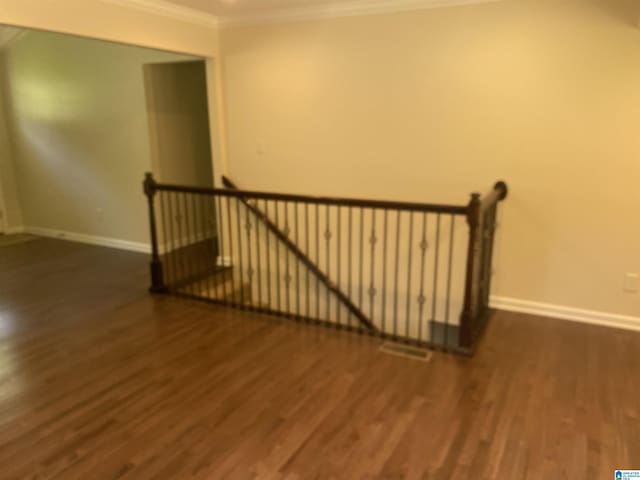 stairway with hardwood / wood-style flooring and ornamental molding