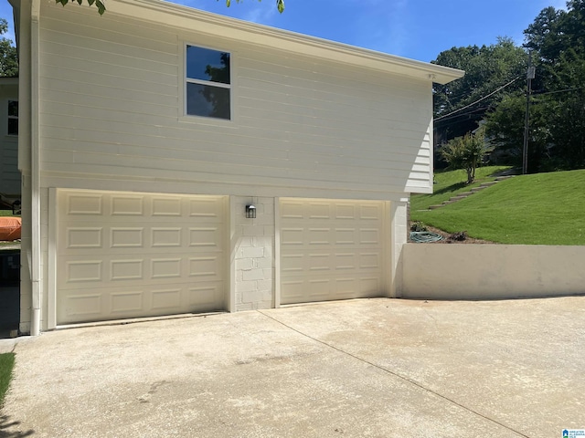 view of side of property with a garage and a lawn