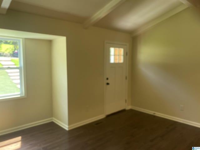 entrance foyer featuring beamed ceiling, plenty of natural light, and dark hardwood / wood-style floors