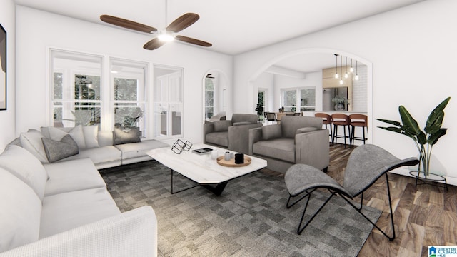 living room featuring ceiling fan with notable chandelier and dark hardwood / wood-style flooring