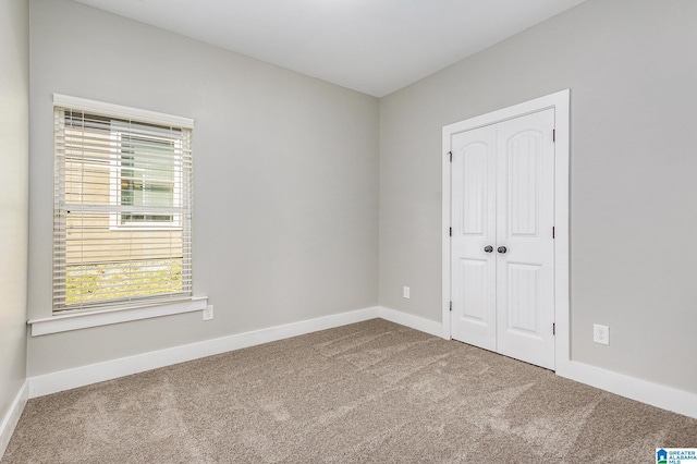 unfurnished bedroom featuring carpet flooring and a closet