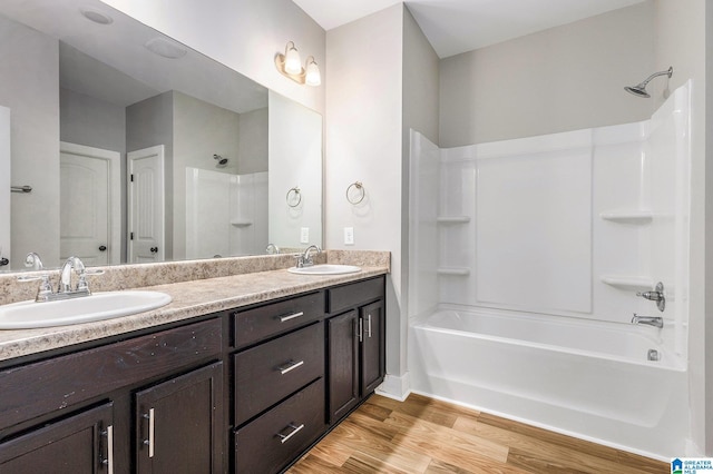 bathroom featuring hardwood / wood-style floors, vanity, and  shower combination