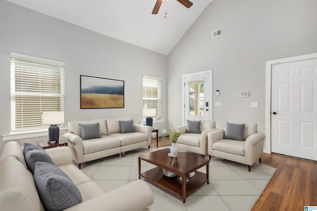 living room featuring ceiling fan, light wood-type flooring, and high vaulted ceiling